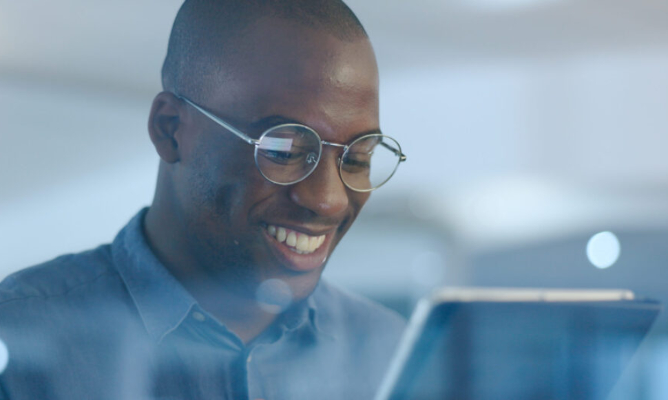 Networking, smile and black man in office on tablet for web design ideas, online project and websit.