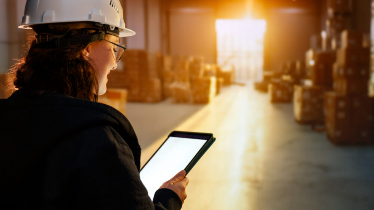 Young woman working in a warehouse using NetSuite ERP for inventory management