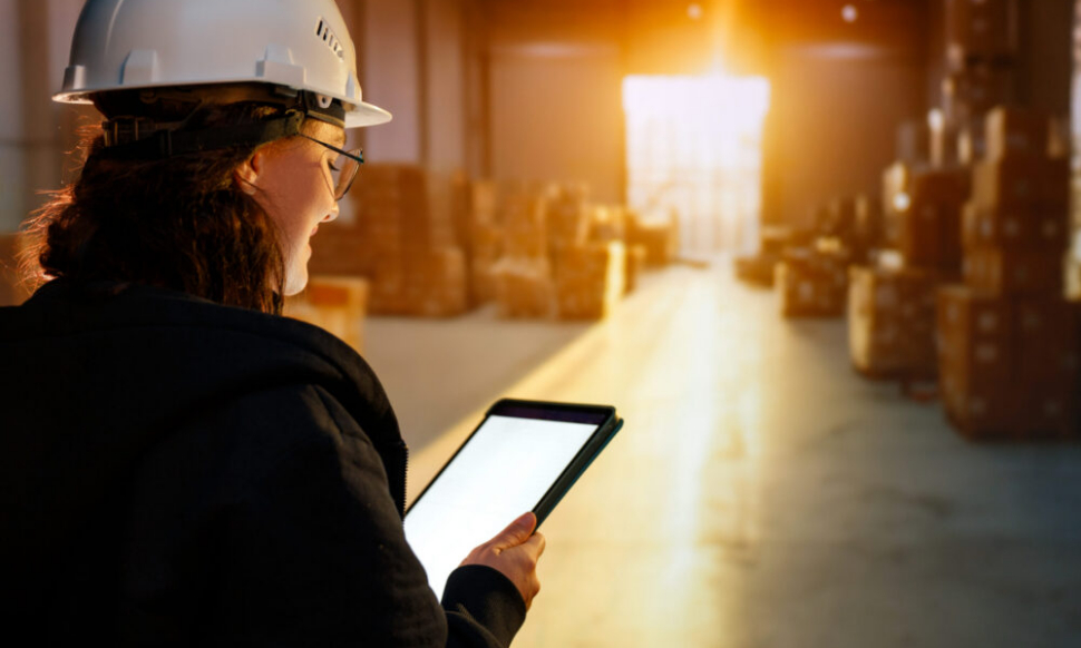 Young woman working in a warehouse using NetSuite ERP for inventory management