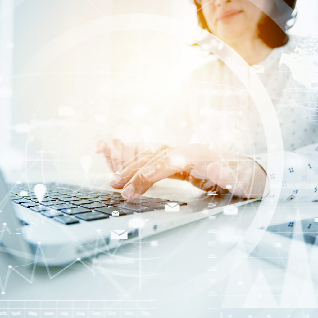 Woman typing on laptop with data overlay representing AI powered accounting software and accounting software with AI insights.